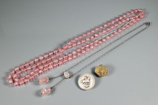 An eary 20th century necklace formed of rose quartz ovoid drops from an oval centrepiece on white