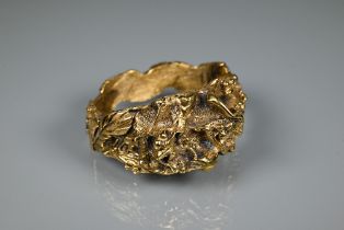 Trifari - A gilt metal bangle of sculptural naturalistic form, half hinged with concealed clasp, 6