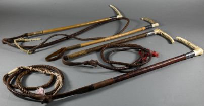 Four silver-mounted driving whips with antler handles - three with braided leather lashes