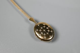A 9ct yellow gold oval double locket set with 17 small diamonds in star arrangement, on 9ct yellow
