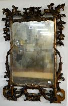 A George III carved and moulded giltwood framed mirror, the plate displaying patination through age,
