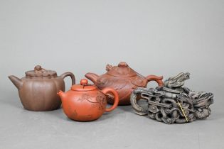 Four Chinese Yixing teapots; a lobed teapot and cover with guardian lion finial 10 cm; a 'dragon'