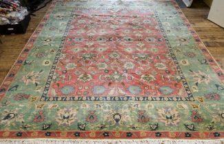 An old Indian Agra carpet, predominantly pale green and pink, 352 cm x 278 cm