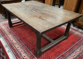 An antique oak refectory table, the wide four plank top over a plain frieze and joint frame with