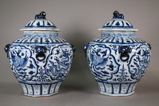 A pair of Chinese Ming style octagonal jars and covers with lion finials and lion mask ringed
