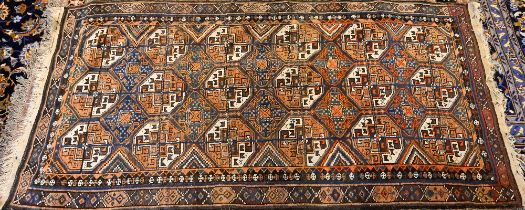 An antique Kurdish rug runner, the field of octagonal tiles on blue-brown ground, 226 cm x 117 cm