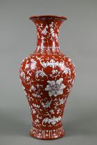 A Chinese coral ground baluster vase painted in white enamels with four bats and composite floral