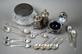 A heavy quality silver three-piece condiment set and various teaspoons and a silver-topped glass