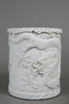 A Chinese monochrome cylindrical brush pot, bitong, the exterior decorated in high relief with a