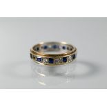 A 9ct yellow and white gold eternity ring set alternate blue sapphires and white stones, size O,