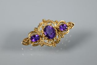 A Victorian-style 9ct yellow gold brooch set with three oval amethysts in Gothic setting, 4 cm long,