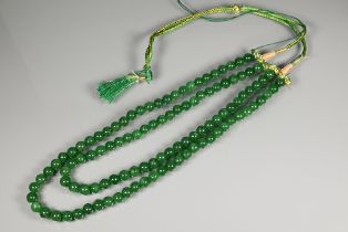 A double row of uniform round emerald beads, on silk cord, 0.8 cm diam