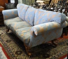 An walnut and upholstered three-seat sofa with blue and brown/gold upholstery / cushions, raised