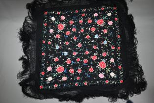 A Chinese silk fringed piano shawl, the black ground richly decorated with flowers and foliage,