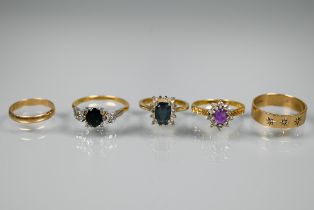 Five various gold rings including a 9ct yellow gold wide wedding band set three starburst