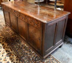 A very large early 18th century oak coffer, the three plank top over a moulded frieze and four panel