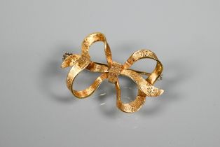 An 18ct yellow gold brooch formed as a ribboned bow, with engraved decoration, 3.5 x 2cm, approx 5.