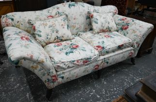 A Georgian style hump back scroll arm sofa, in floral Colefax & Fowler fabric, raised on three front