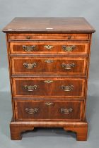 A well executed Georgian style small cross and feather-banded walnut chest of four drawers beneath a