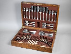 An oak canteen fitted with a set of silver Hanoverian rat-tail flatware and cutlery, comprising