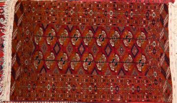 A traditional Russian Turkoman rug, the brown red ground with two rows of guls, 133 cm x 74 cm
