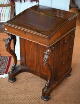 A Victorian rosewood davenport desk, the sloped hinged top inset with brown leather, four side