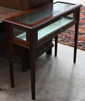 A mahogany veneered and glazed vitrine display cabinet with hinged top and tapering square supports,