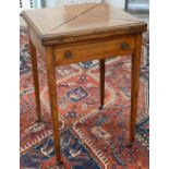 An Edwardian walnut crossbanded envelope card table with frieze drawer and tapering square