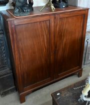 A 19th century mahogany linen press with panelled doors enclosing five slides standing on bracket