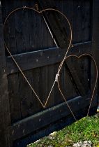 A pair of weathered steel heart shaped garden plant frames, 80 cm w x 105 cm h