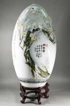 A large 20th century Chinese porcelain egg painted in polychrome enamels with a winter landscape and