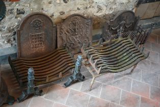 Two old cast iron fire backs to/with three fire baskets, a large cast iron trivet and a pair of fire