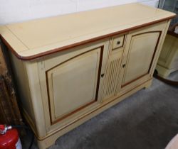 A French cream painted sideboard by Le Creuset, the two panelled cupboard doors separated by