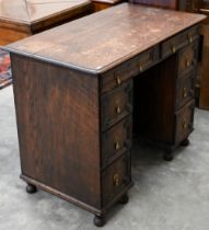 A 19th century Jacobean style oak kneehole desk with eight drawers around the central recessed