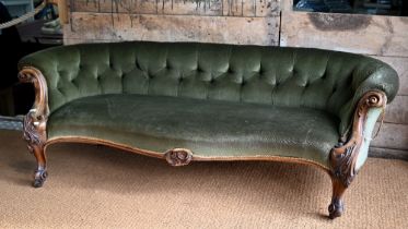 A green button back draylon upholstered Victorian walnut framed serpentine front sofa, on castors.