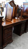 A modern stained hardwood dressing table with bevelled triptych mirror and nine drawers, 150 cm wide