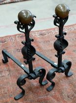 Pair of wrought iron and copper fire dogs, to/w a cast iron fireside companion suit of armour (lacks