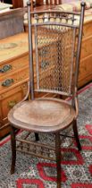 An early 20th century side chair with chain mail rattan back and pressed/embossed seat