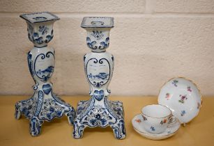 A pair of Delft blue and white candlesticks 24 cm high to/w a Meissen coffee cup and two saucers,