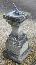 A weathered cast stone obelisk sundial