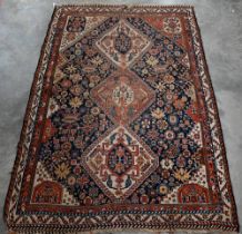 SW Persian Shiraz triple diamond medallion and stylised floral design on navy blue ground, red/cream