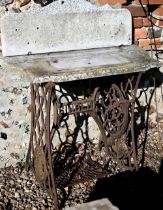 A vintage Singer cast iron treadle sewing machine base with associated stone top and splash back,