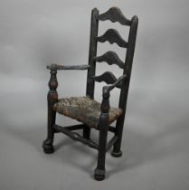 An antique miniature ladderback armchair with rush seat, 35 cm