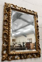 A bevelled rectangular wall mirror in foliate giltwood and gesso frame