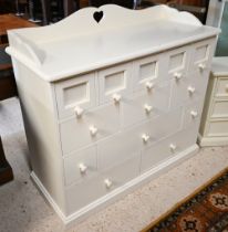 An off-white painted child's bedroom chest, arrangement of thirteen drawers and galleried back