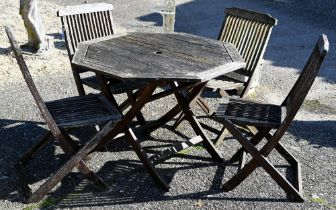A weathered octagonal garden table and four chairs (5)