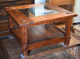 A rustic stained hardwood square coffee table with inset glass top and open under-tier, 80 x 80 x 50