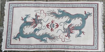 A modern Chinese cut wool pictorial rug with two dragons disputing a flaming pearl on cream