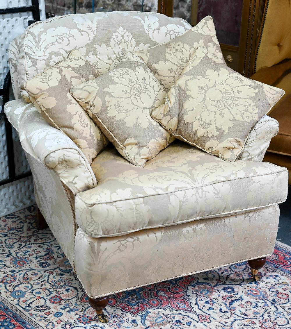 A contemporary cream/gold floral upholstered wing armchair by Duresta to/with an easy armchair in
