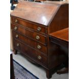 A George III mahogany fall front bureau with four long graduating drawers and shaped bracket feet (